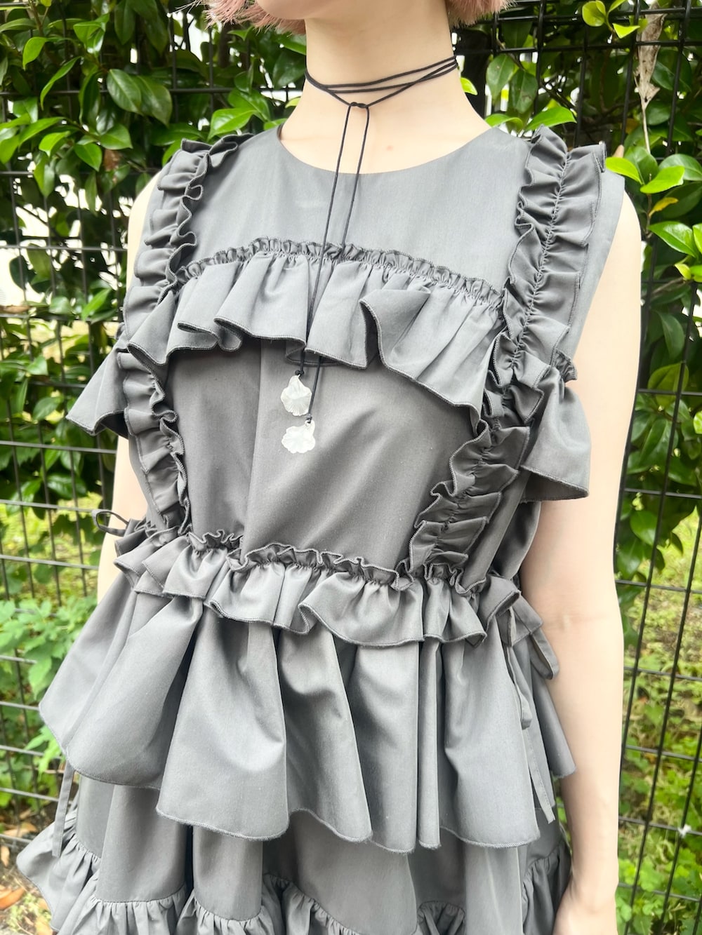 グレー系のワンピース、ブラウン系のハンドバッグ、ブラック系のブーツを着用したレディースの夏コーディネートの9枚目の写真