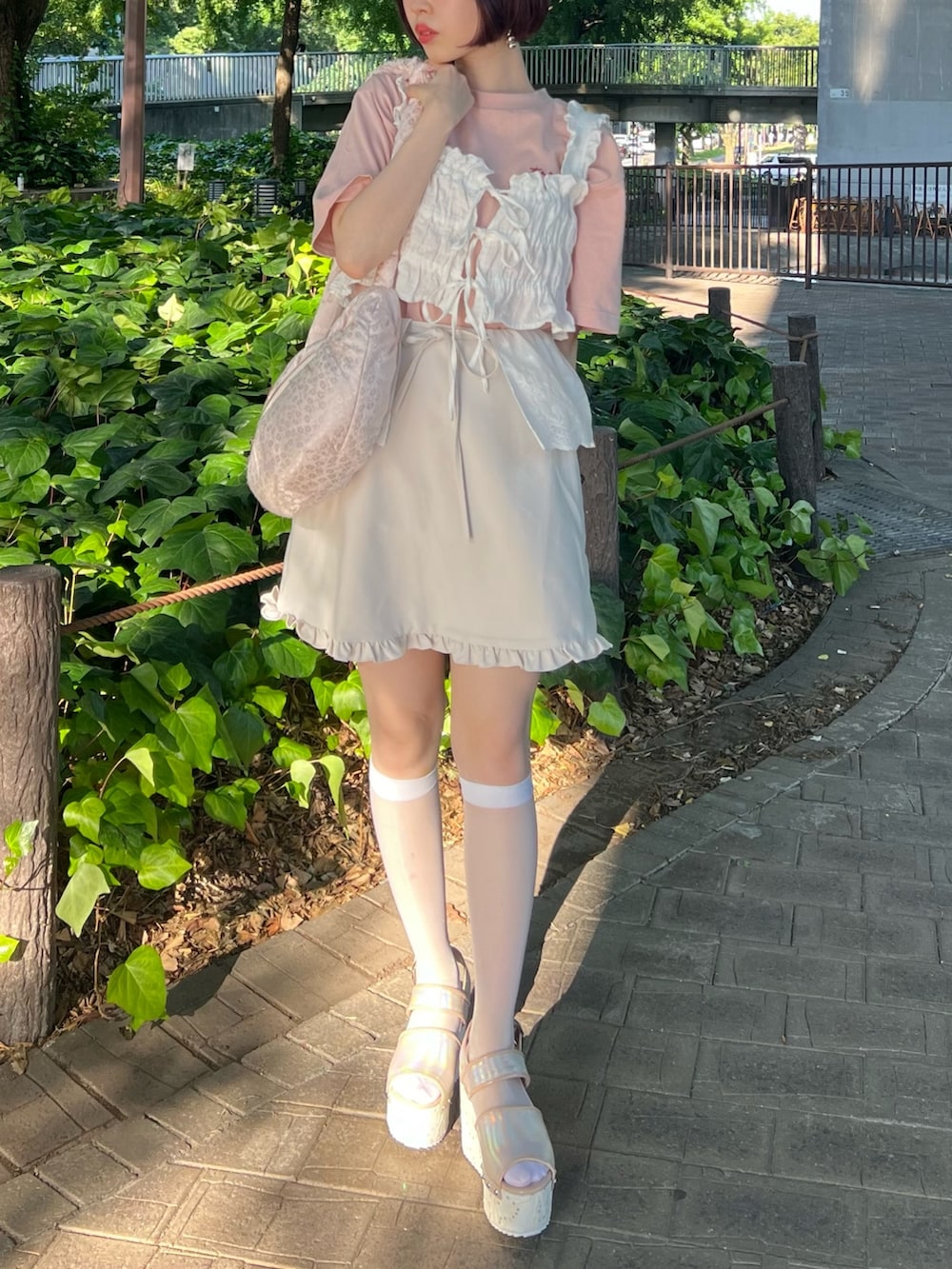 ピンク系のサンダル、ピンク系のボディバッグ/ウエストポーチ、ホワイト系のスカートを着用したレディースの夏コーディネートの2枚目の写真