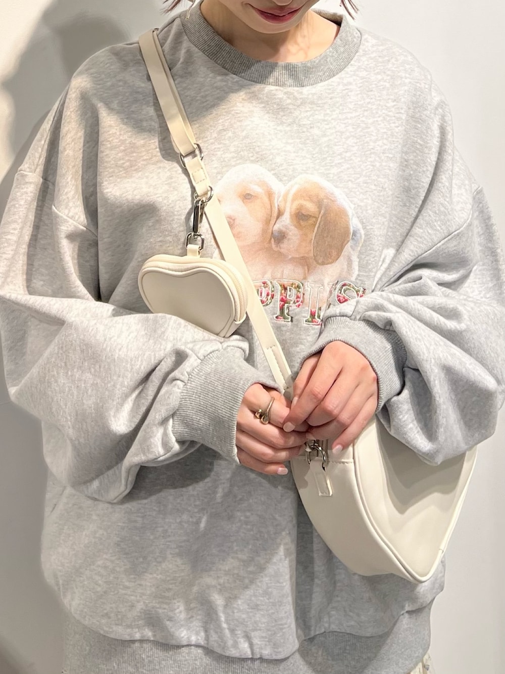 ホワイト系のショルダーバッグ、ホワイト系のスニーカー、ブルー系のスカートを着用したレディースの冬コーディネートの6枚目の写真