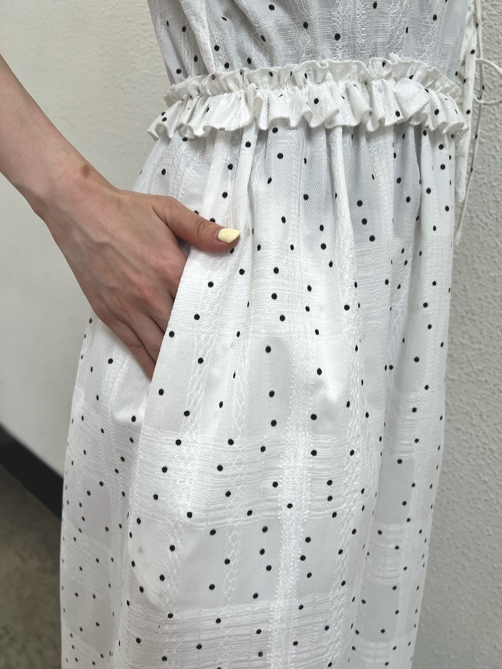 ホワイト系のワンピース、レッド系のハンドバッグ、ブラック系のパンプスを着用したレディースの春コーディネートの8枚目の写真
