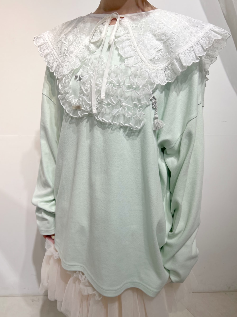 グリーン系のTシャツ/カットソー、ピンク系のスカート、ホワイト系のスニーカーを着用したレディースの夏コーディネートの6枚目の写真