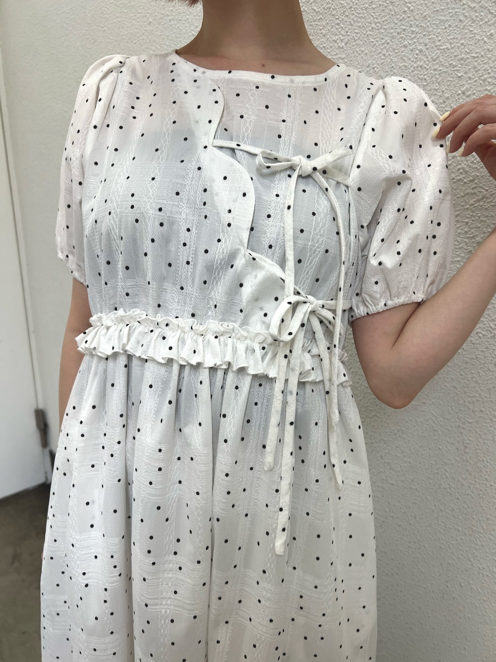 ホワイト系のワンピース、レッド系のハンドバッグ、ブラック系のパンプスを着用したレディースの春コーディネートの9枚目の写真