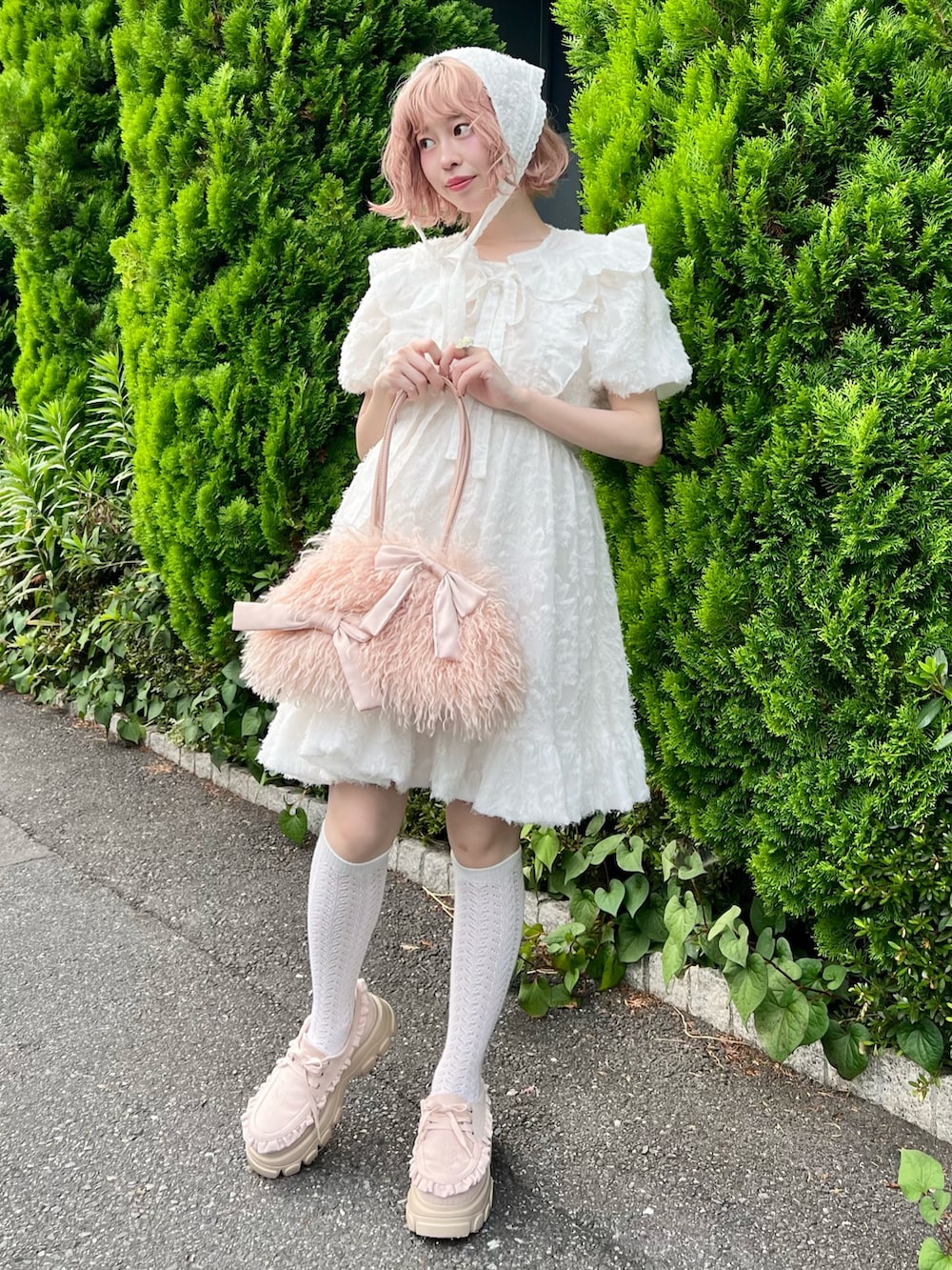 ホワイト系のワンピース、ピンク系のボストンバッグ、ピンク系のローファーを着用したレディースの夏コーディネートの2枚目の写真