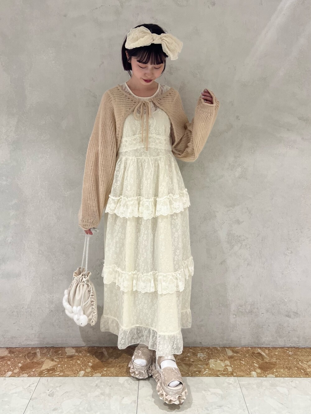 ベージュ系のカーディガン/ボレロ、ホワイト系のワンピース、ホワイト系のショルダーバッグを着用したレディースの夏コーディネートの2枚目の写真