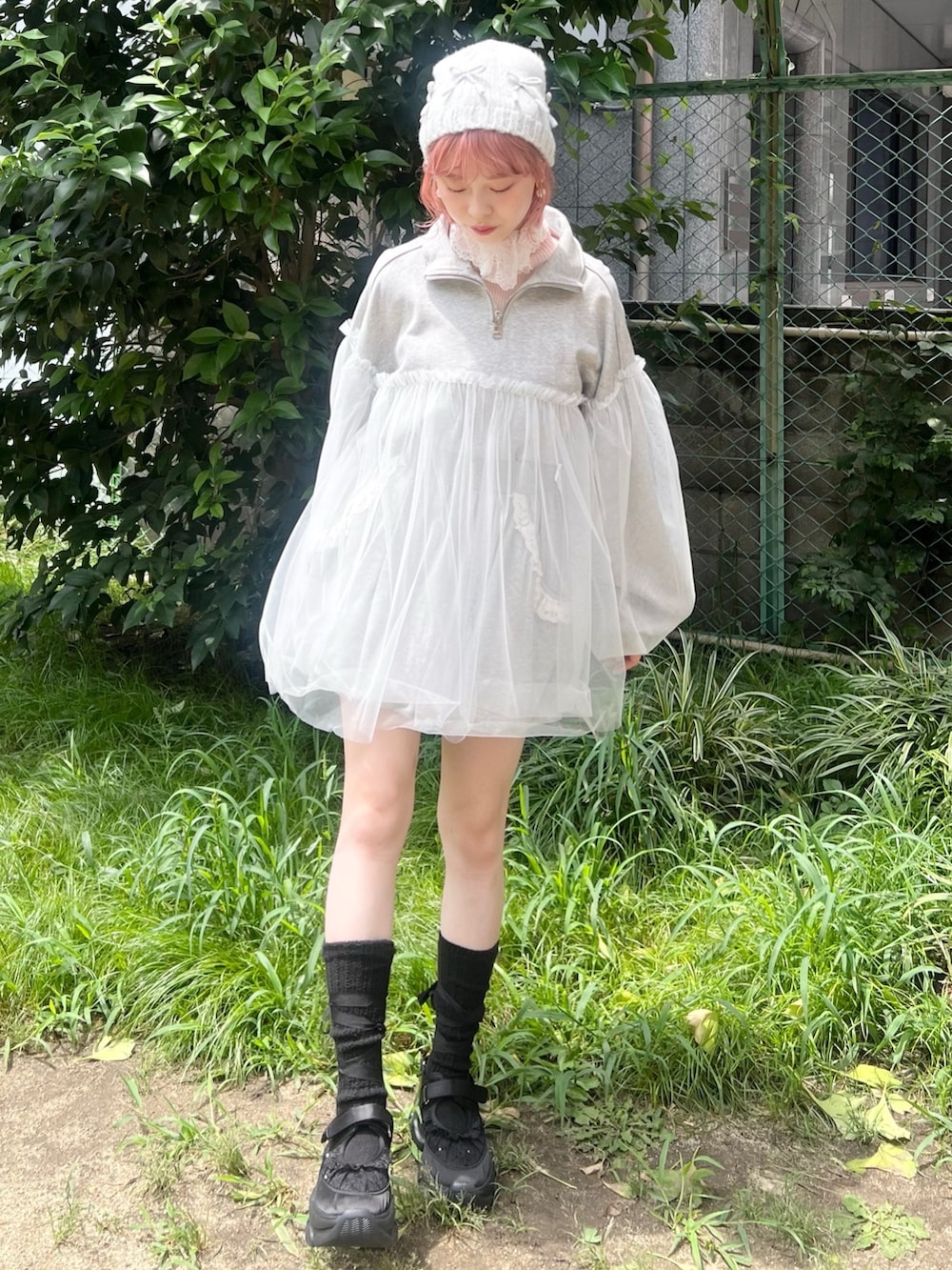 グレー系のスウェット、ピンク系のニット/セーター、ブルー系のショルダーバッグを着用したレディースの秋コーディネートの2枚目の写真