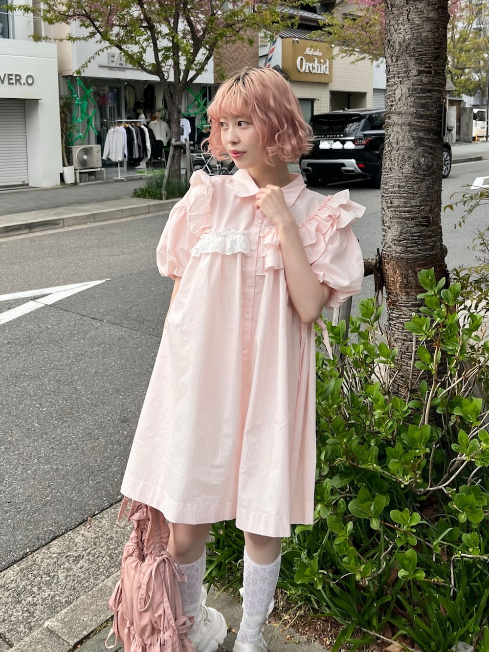 ピンク系のワンピース、ピンク系のトートバッグ、ホワイト系のスニーカーを着用したレディースの春コーディネートの3枚目の写真