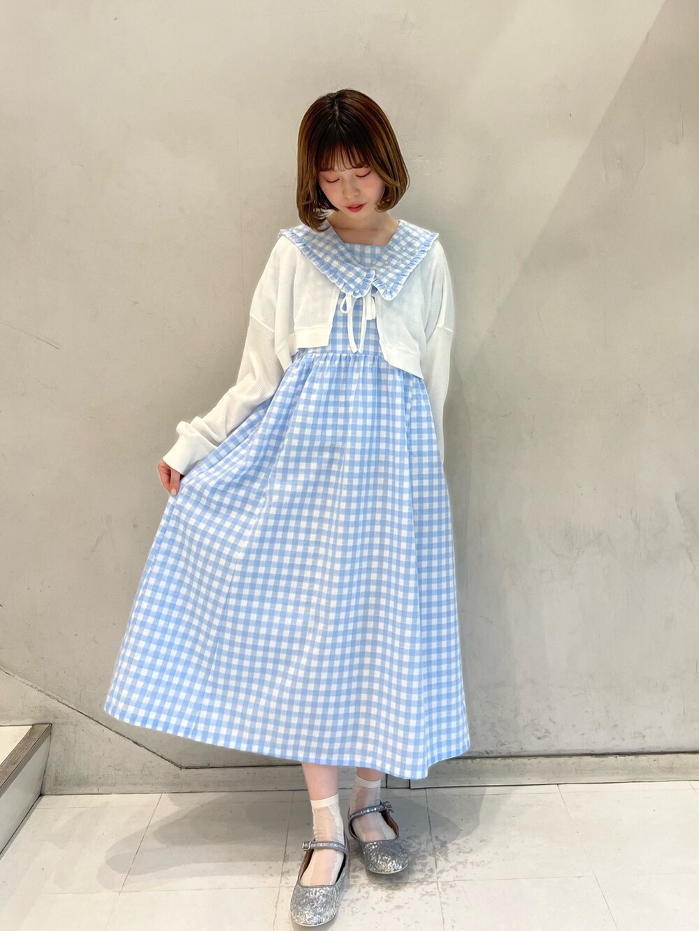 ホワイト系のトートバッグ、シルバー系のパンプス、ブルー系のワンピースを着用したレディースの春コーディネートの2枚目の写真