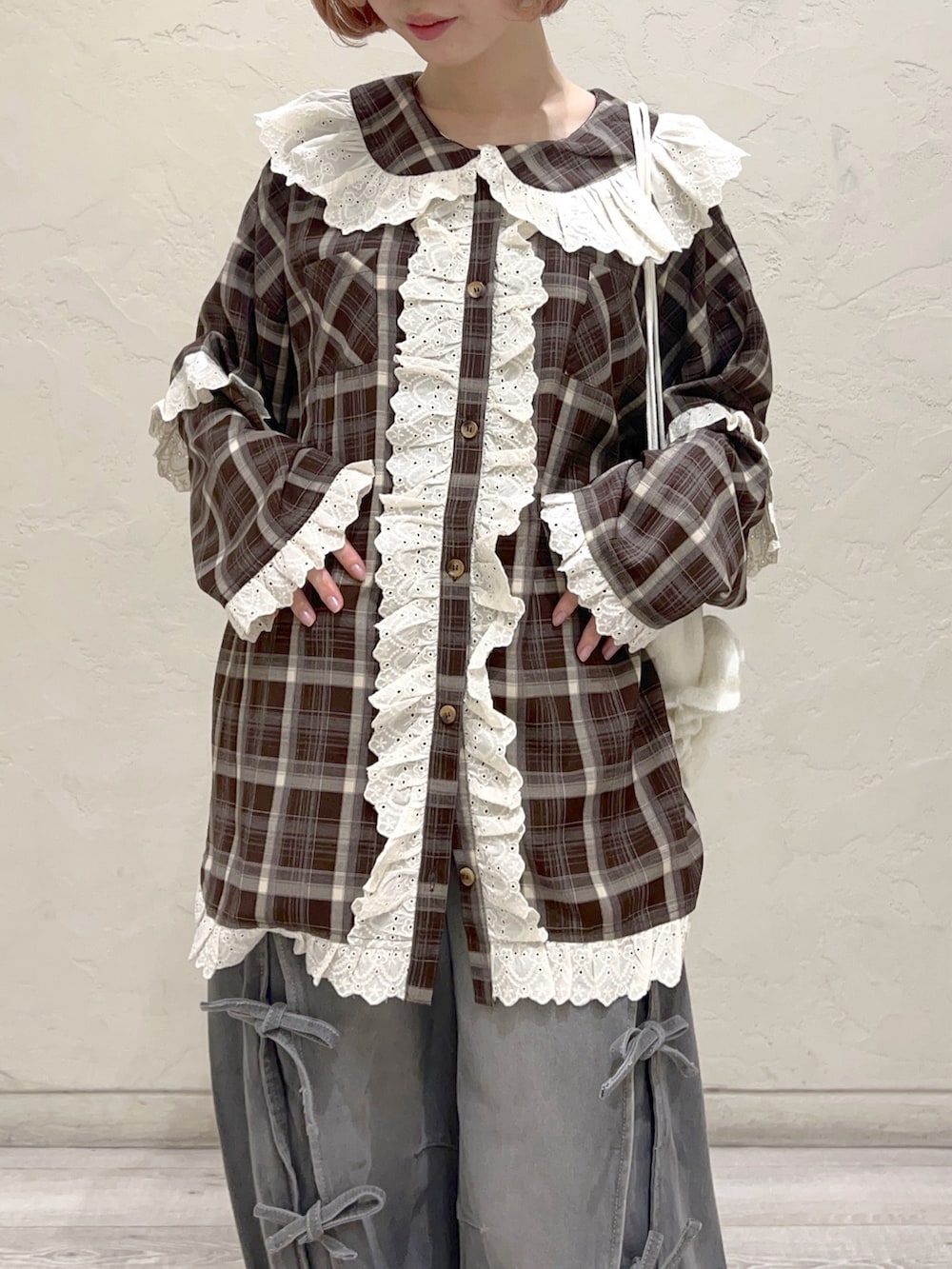 ブラウン系のシャツ/ブラウス、グレー系のデニムパンツ、ホワイト系のスニーカーを着用したレディースの秋コーディネートの9枚目の写真