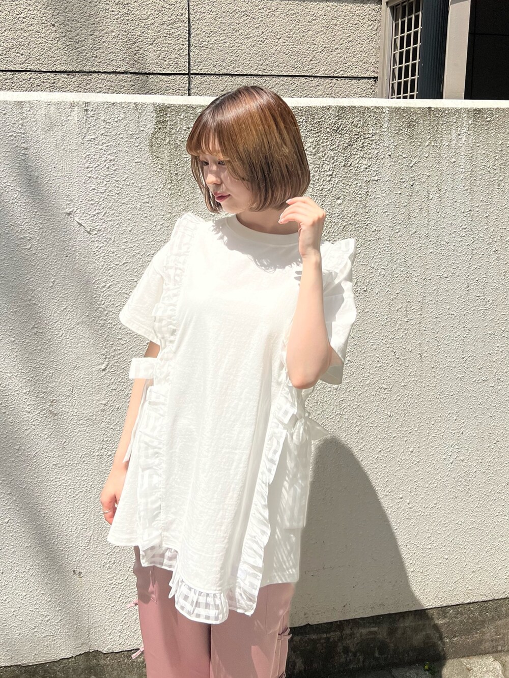 ピンク系のカーゴパンツ、ホワイト系のTシャツ/カットソー、ホワイト系のサンダルを着用したレディースの春コーディネートの5枚目の写真