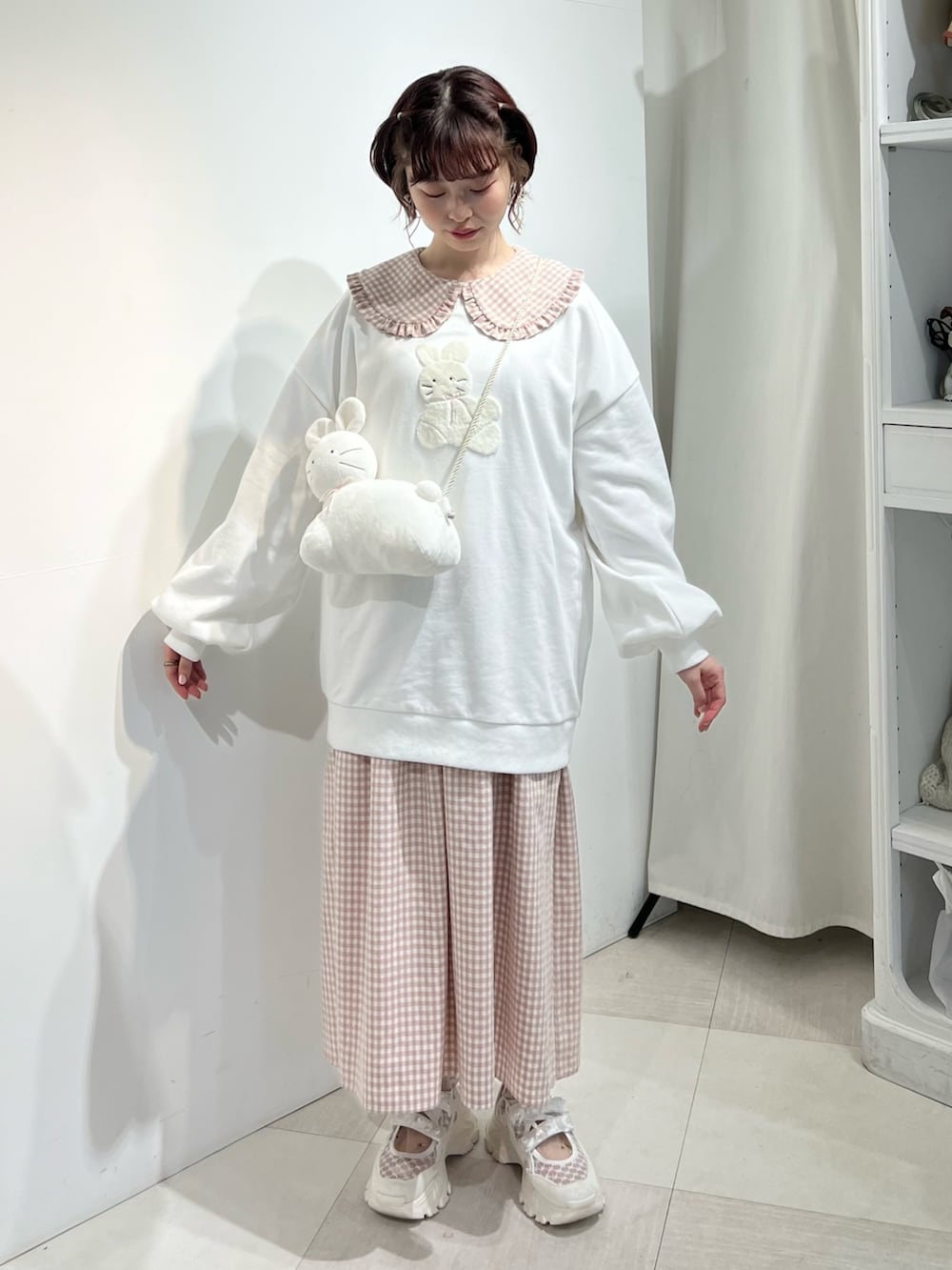 ホワイト系のショルダーバッグ、ピンク系のワンピース、ホワイト系のスウェットを着用したレディースの冬コーディネートの2枚目の写真