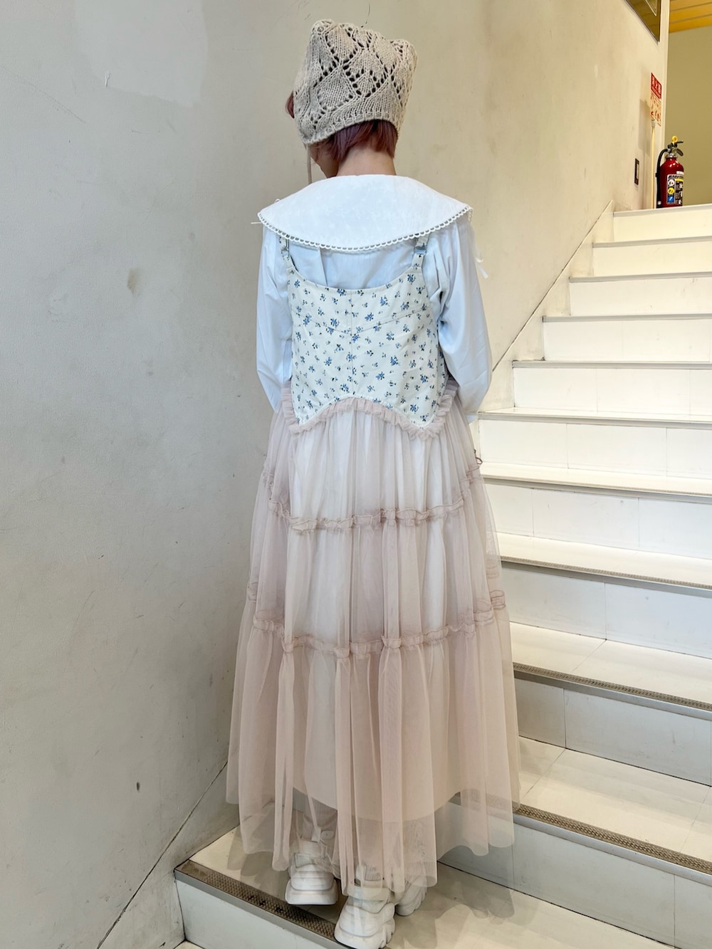 ピンク系のカーディガン/ボレロ、ホワイト系のシャツ/ブラウス、ピンク系のワンピースを着用したレディースの冬コーディネートの5枚目の写真