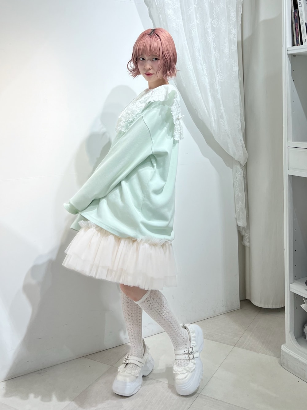 グリーン系のTシャツ/カットソー、ピンク系のスカート、ホワイト系のスニーカーを着用したレディースの夏コーディネートの2枚目の写真