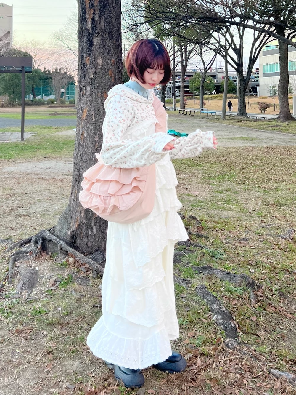 ホワイト系のワンピース、その他のカーディガン/ボレロ、ピンク系のショルダーバッグを着用したレディースの冬コーディネートの5枚目の写真