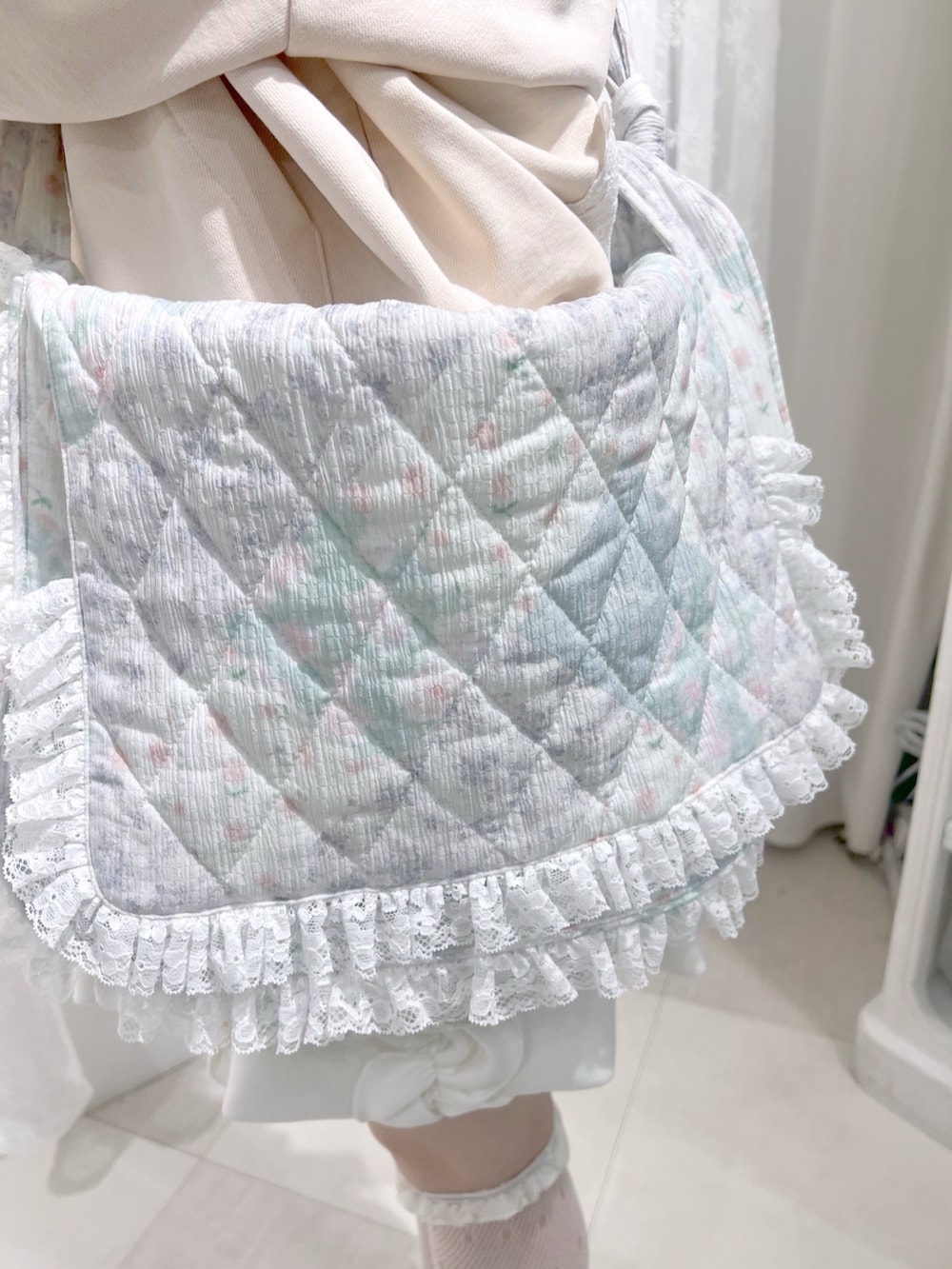 ピンク系のパーカー、ホワイト系のショルダーバッグ、ホワイト系のスカートを着用したレディースの秋コーディネートの9枚目の写真