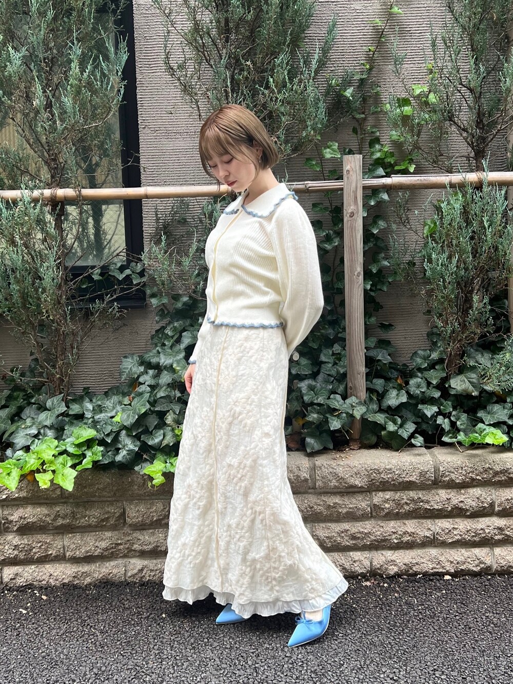 ホワイト系のニット/セーター、ホワイト系のワンピース、ブルー系のパンプスを着用したレディースの冬コーディネートの3枚目の写真