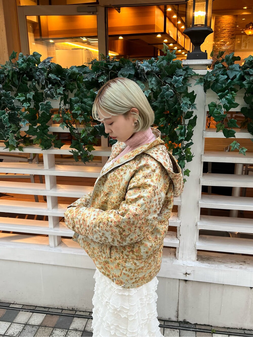 イエロー系のマウンテンパーカー、ホワイト系のブーツ、ホワイト系のワンピースを着用したレディースの秋コーディネートの6枚目の写真