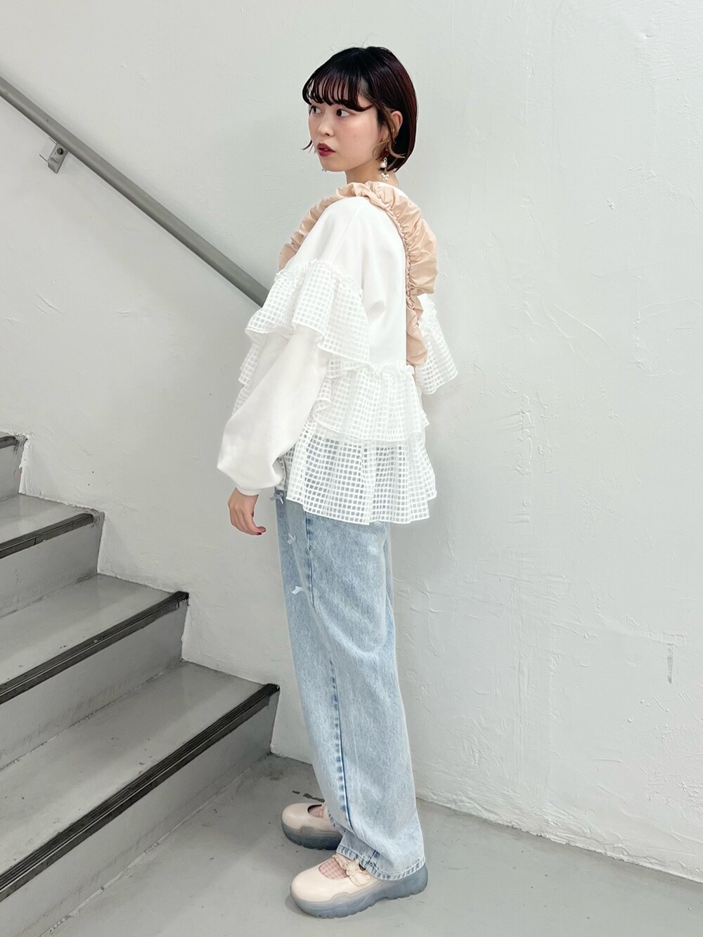 ホワイト系のスウェット、ブルー系のデニムパンツ、ホワイト系のスニーカーを着用したレディースの春コーディネートの2枚目の写真