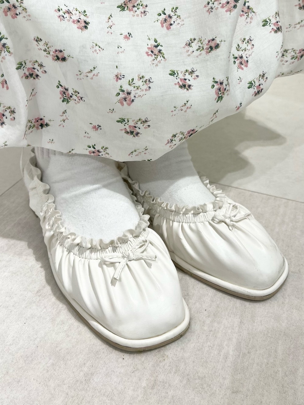 ホワイト系のパンプス、ホワイト系のカーディガン/ボレロ、ホワイト系のTシャツ/カットソーを着用したレディースの春コーディネートの8枚目の写真