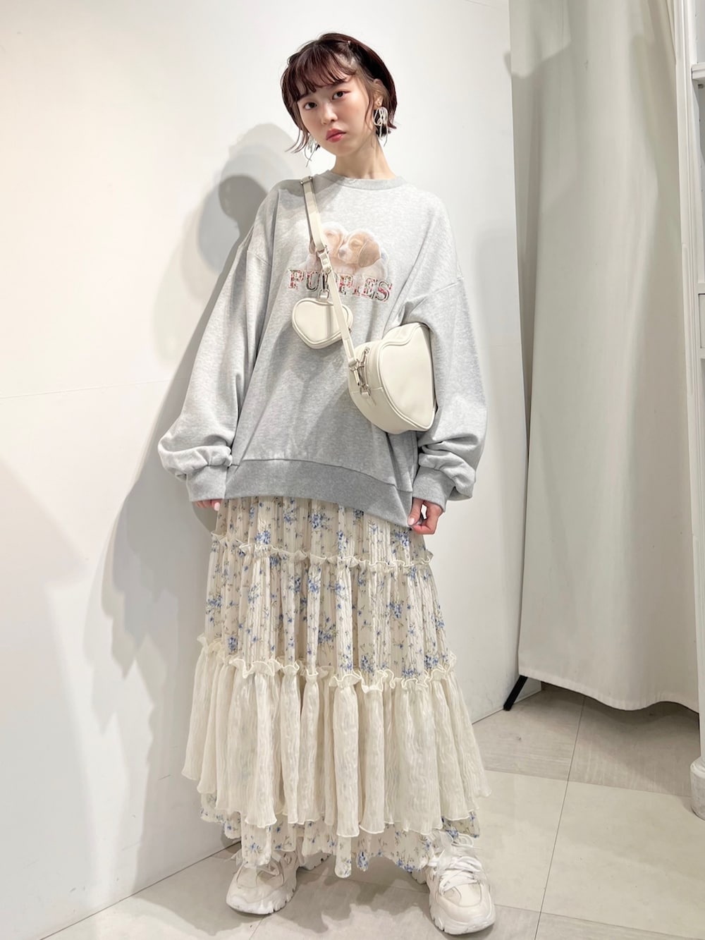 ホワイト系のショルダーバッグ、ホワイト系のスニーカー、ブルー系のスカートを着用したレディースの冬コーディネートの3枚目の写真