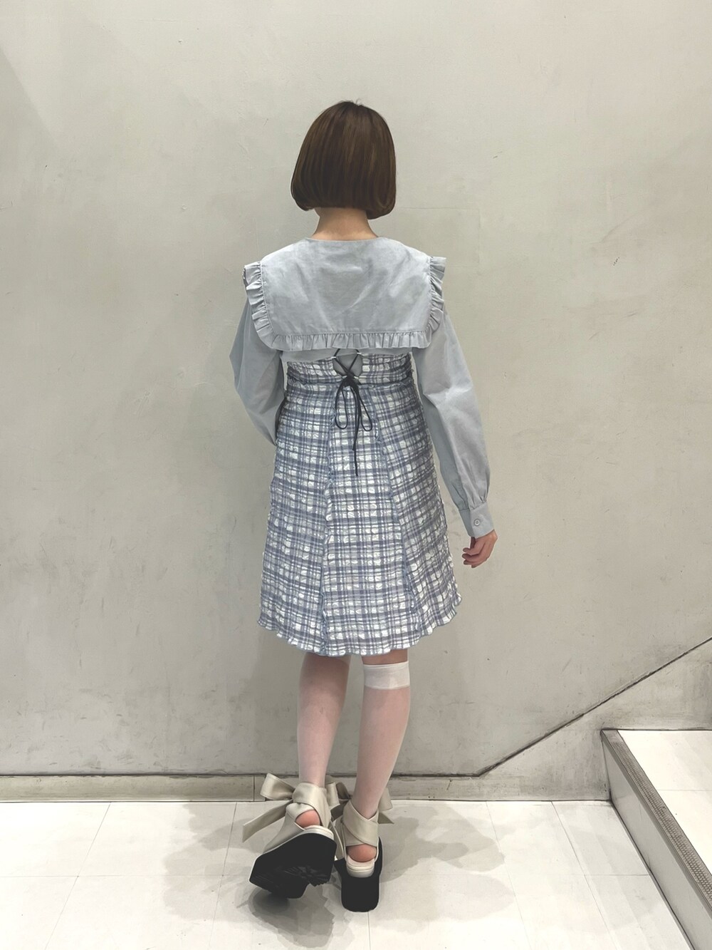 ブルー系のワンピース、ブルー系のシャツ/ブラウス、ホワイト系のパンプスを着用したレディースの春コーディネートの3枚目の写真