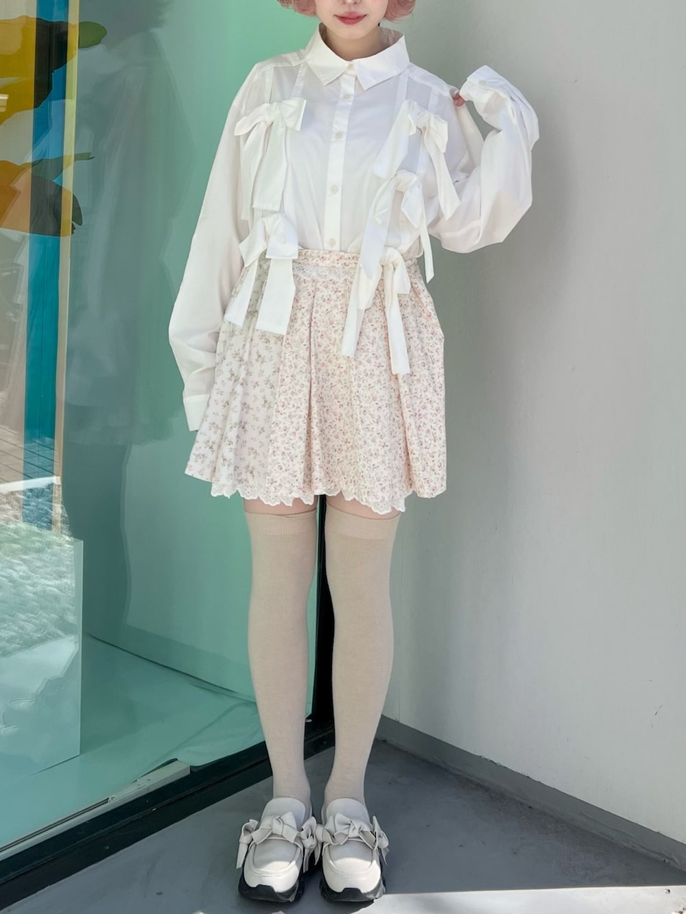 ホワイト系のシャツ/ブラウス、ピンク系のスカート、ホワイト系のスニーカーを着用したレディースの冬コーディネートの5枚目の写真