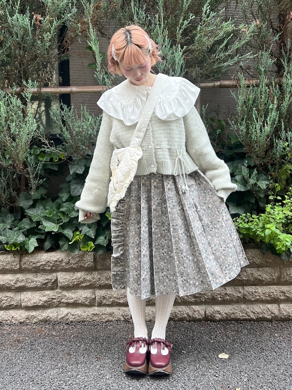 グリーン系のカーディガン/ボレロ、グレー系のスカート、レッド系のバレエシューズを着用したレディースの夏コーディネートの4枚目の写真