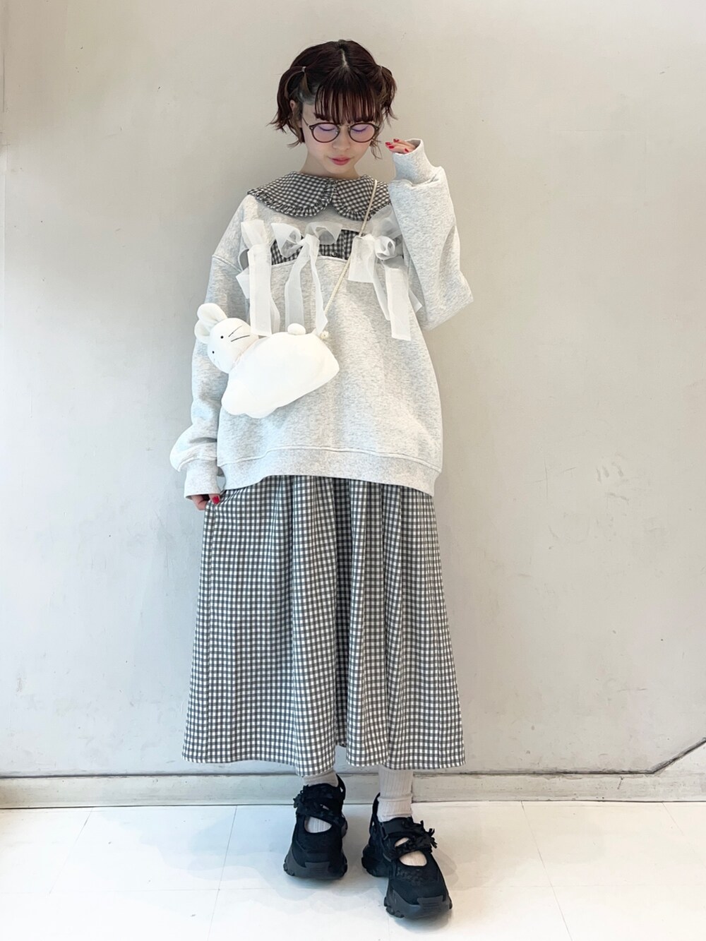 ブラック系のワンピース、ブラック系のスニーカー、ホワイト系のショルダーバッグを着用したレディースの冬コーディネートの5枚目の写真