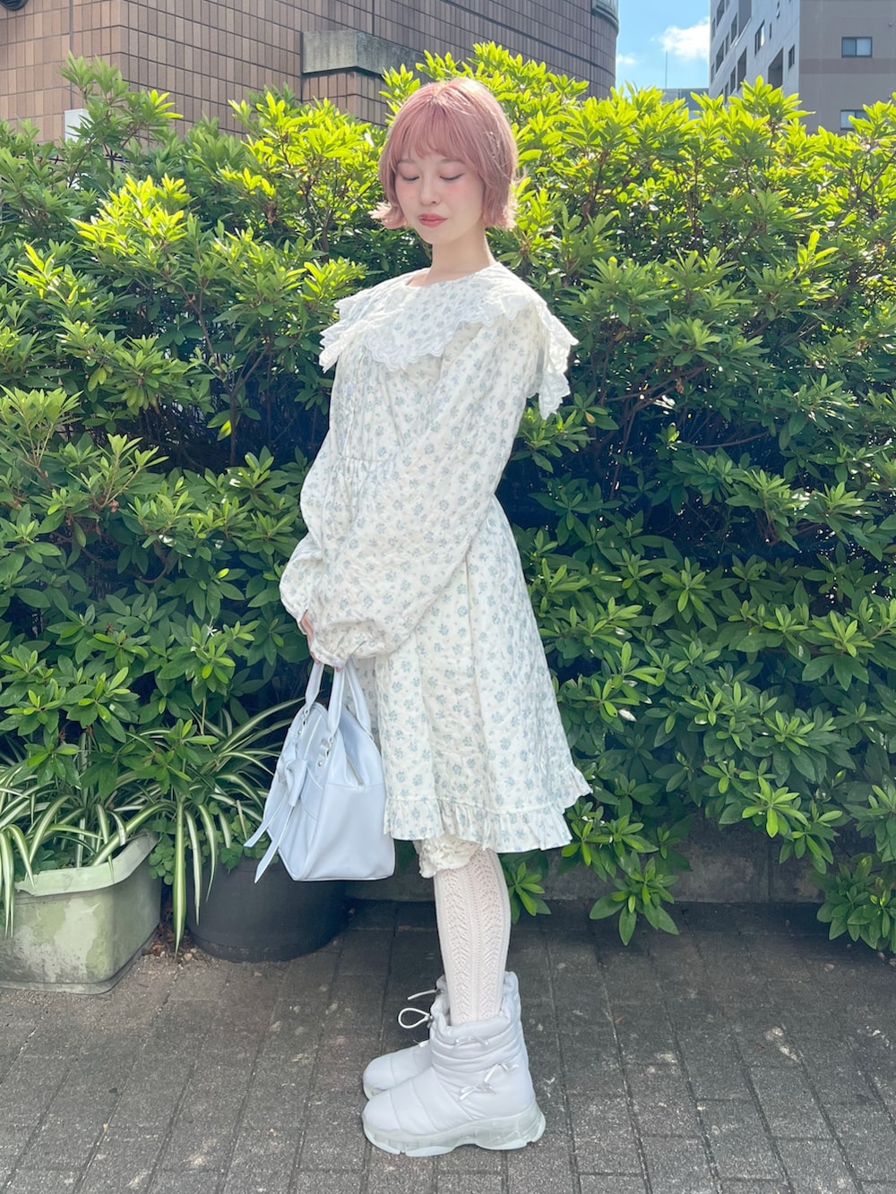 ホワイト系のワンピース、ブルー系のハンドバッグ、ブルー系のブーツを着用したレディースの夏コーディネートの2枚目の写真
