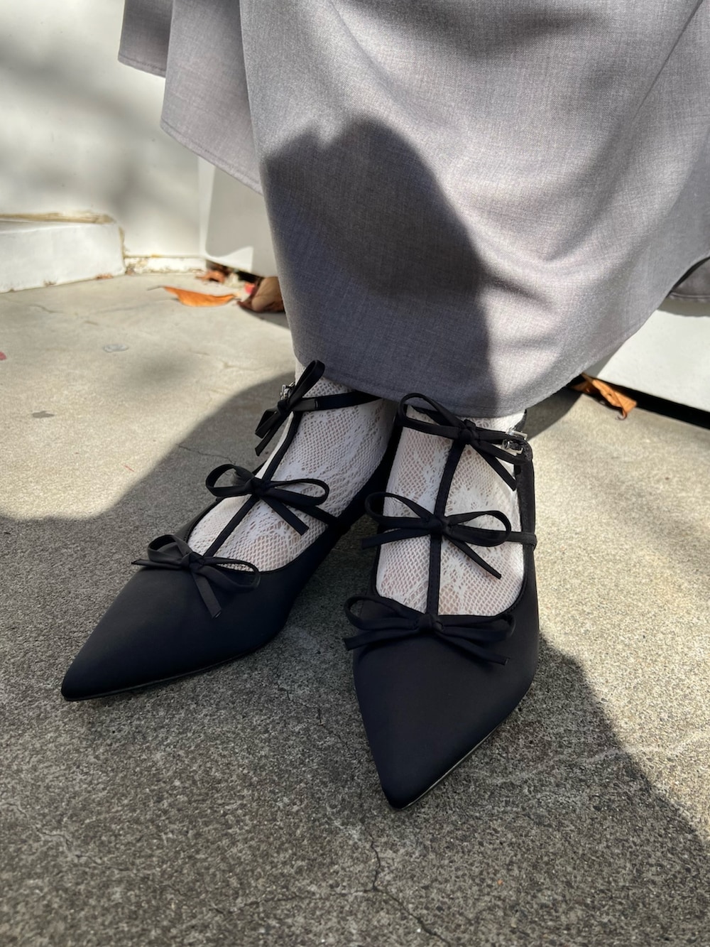 グレー系のテーラードジャケット、グレー系のスカート、ブラック系のパンプスを着用したレディースの秋コーディネートの8枚目の写真