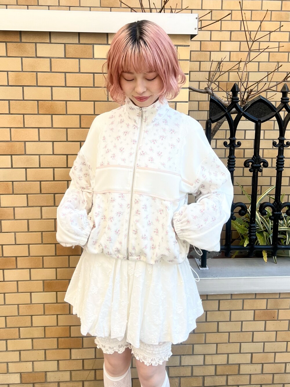 ピンク系のジャージ、ホワイト系のスカート、ホワイト系のスニーカーを着用したレディースの冬コーディネートの7枚目の写真