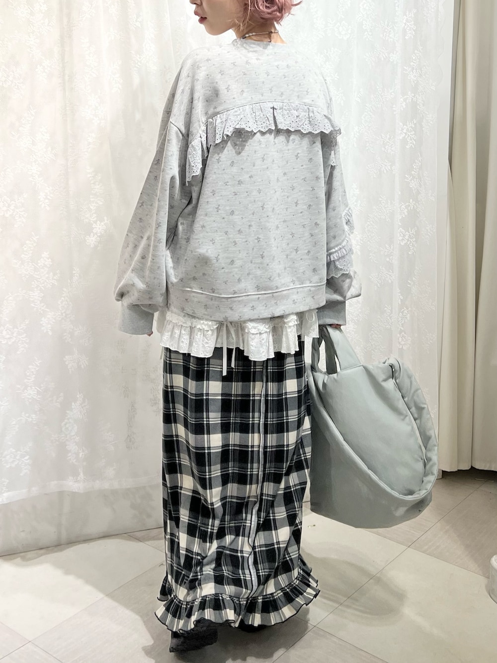 グレー系のスウェット、ベージュ系のスカート、ブラック系のスニーカーを着用したレディースの冬コーディネートの3枚目の写真