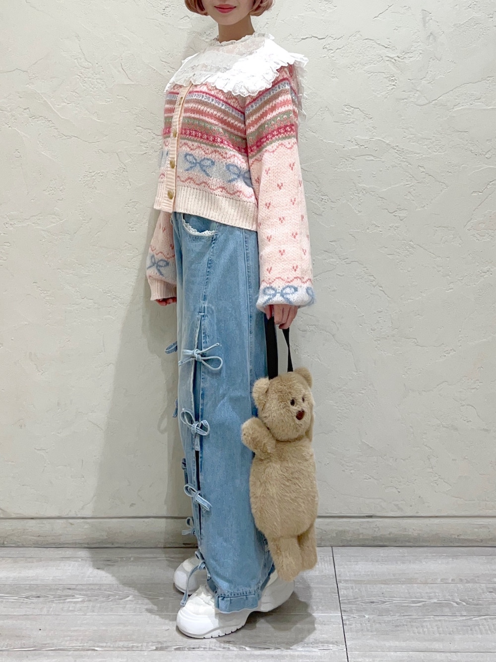 ピンク系のカーディガン/ボレロ、ホワイト系のシャツ/ブラウス、ベージュ系のハンドバッグを着用したレディースの秋コーディネートの4枚目の写真