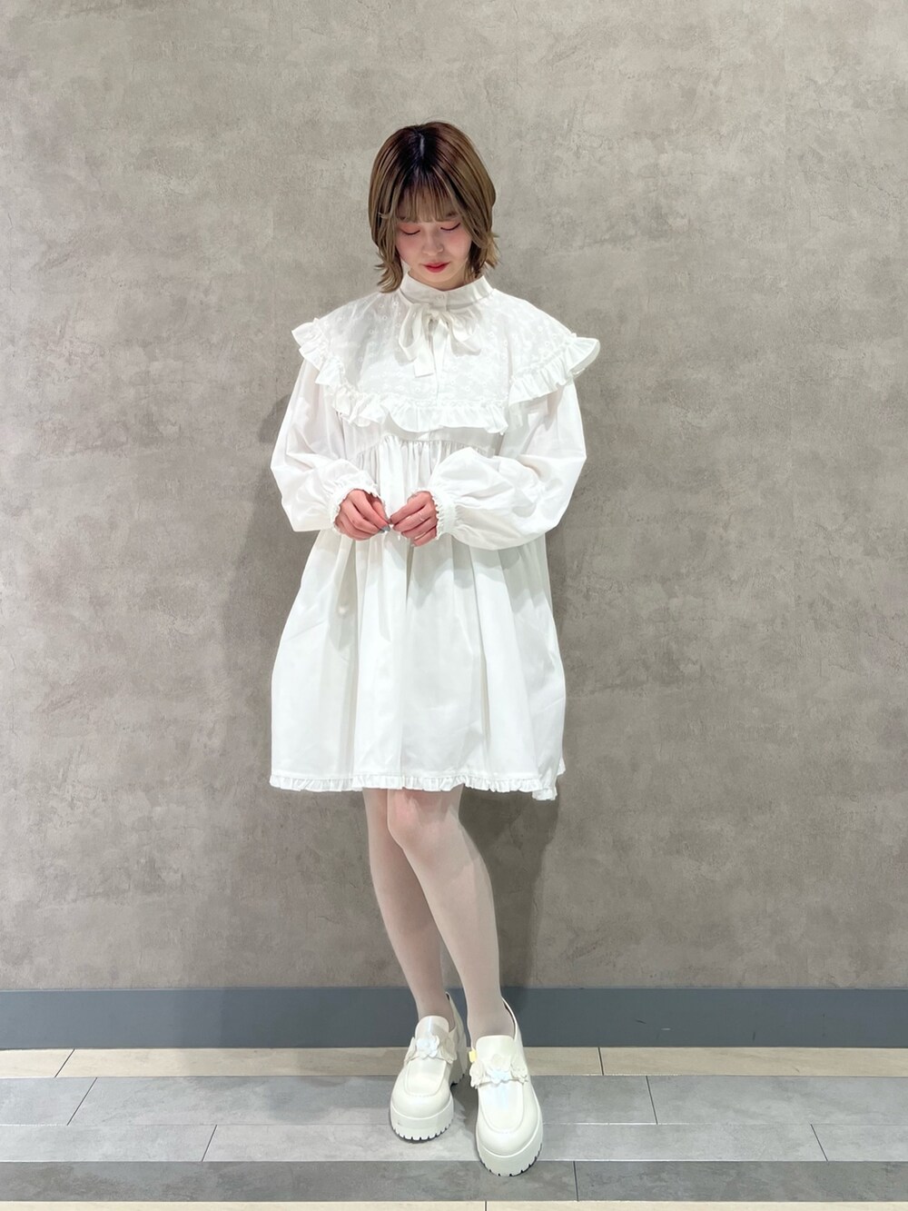 ブルー系のその他アウター、ホワイト系のワンピース、ホワイト系のローファーを着用したレディースの冬コーディネートの5枚目の写真