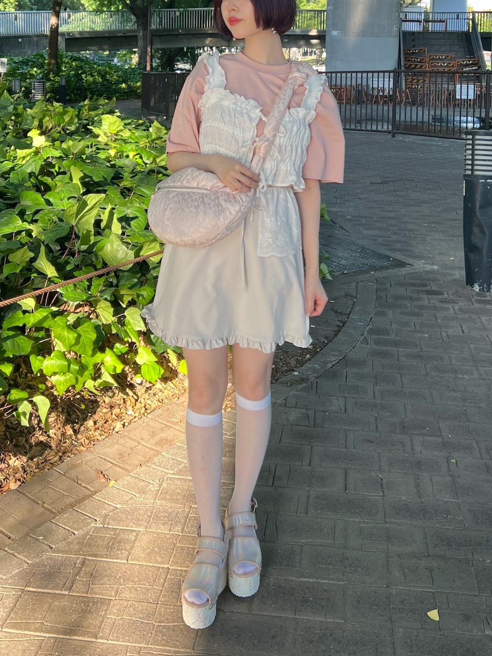 ピンク系のサンダル、ピンク系のボディバッグ/ウエストポーチ、ホワイト系のスカートを着用したレディースの夏コーディネートの3枚目の写真