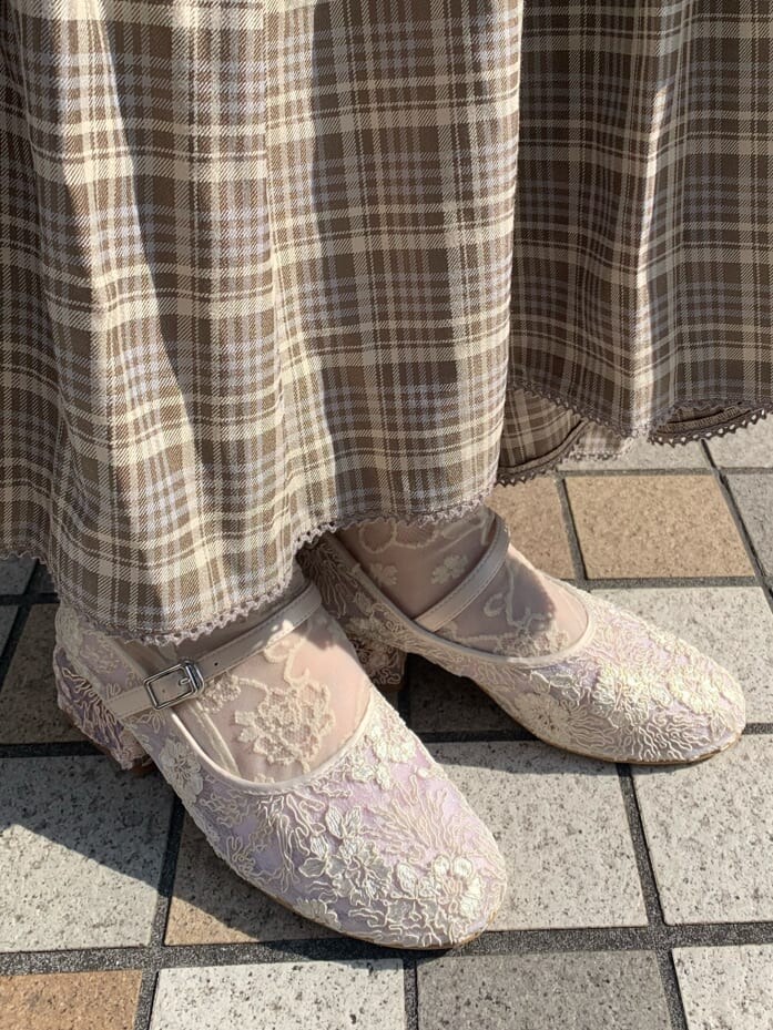 ベージュ系のスカート、ホワイト系のトレンチコート、ホワイト系のパンプスを着用したレディースの冬コーディネートの8枚目の写真
