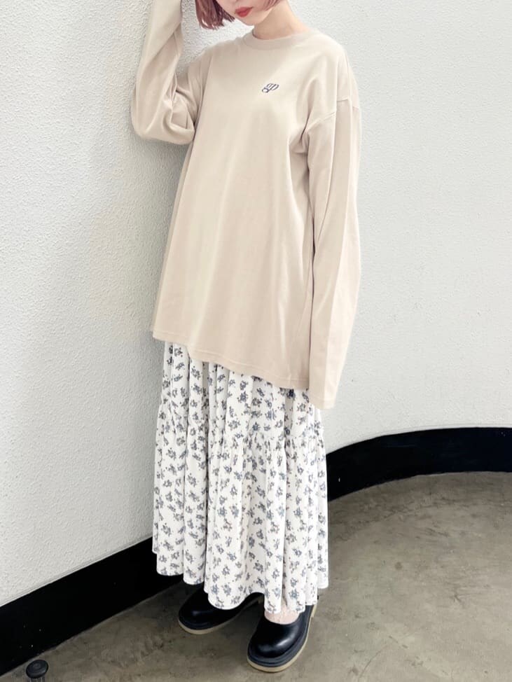 ホワイト系のスカート、ブラック系のパンプス、ベージュ系のTシャツ/カットソーを着用したレディースの夏コーディネートの6枚目の写真