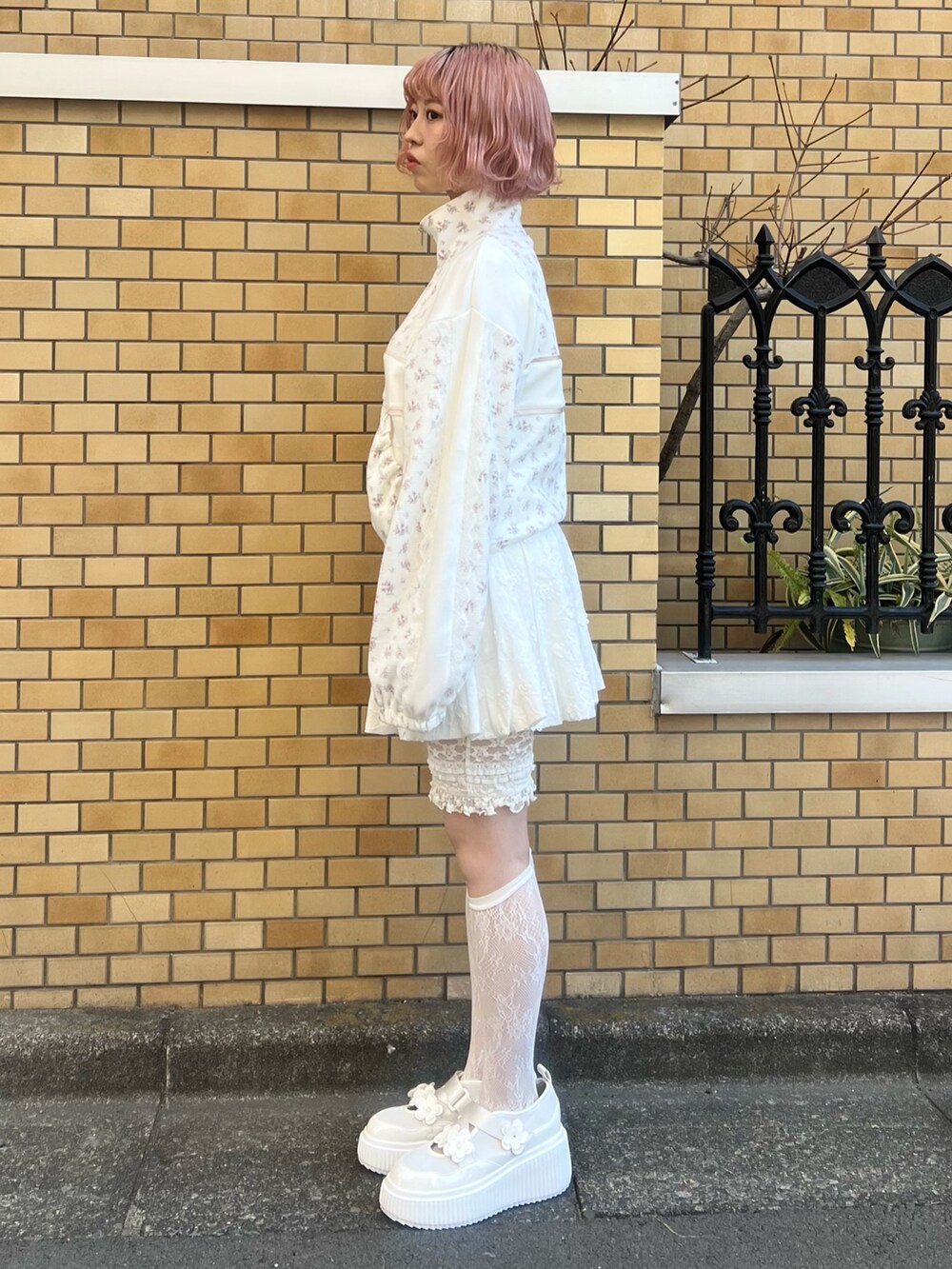 ピンク系のジャージ、ホワイト系のスカート、ホワイト系のスニーカーを着用したレディースの冬コーディネートの6枚目の写真