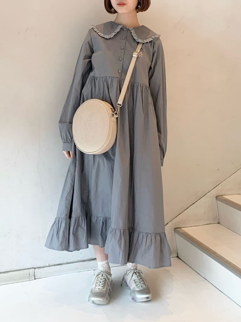 ベージュ系のカーディガン/ボレロ、ホワイト系のスニーカー、ホワイト系のショルダーバッグを着用したレディースの冬コーディネートの5枚目の写真