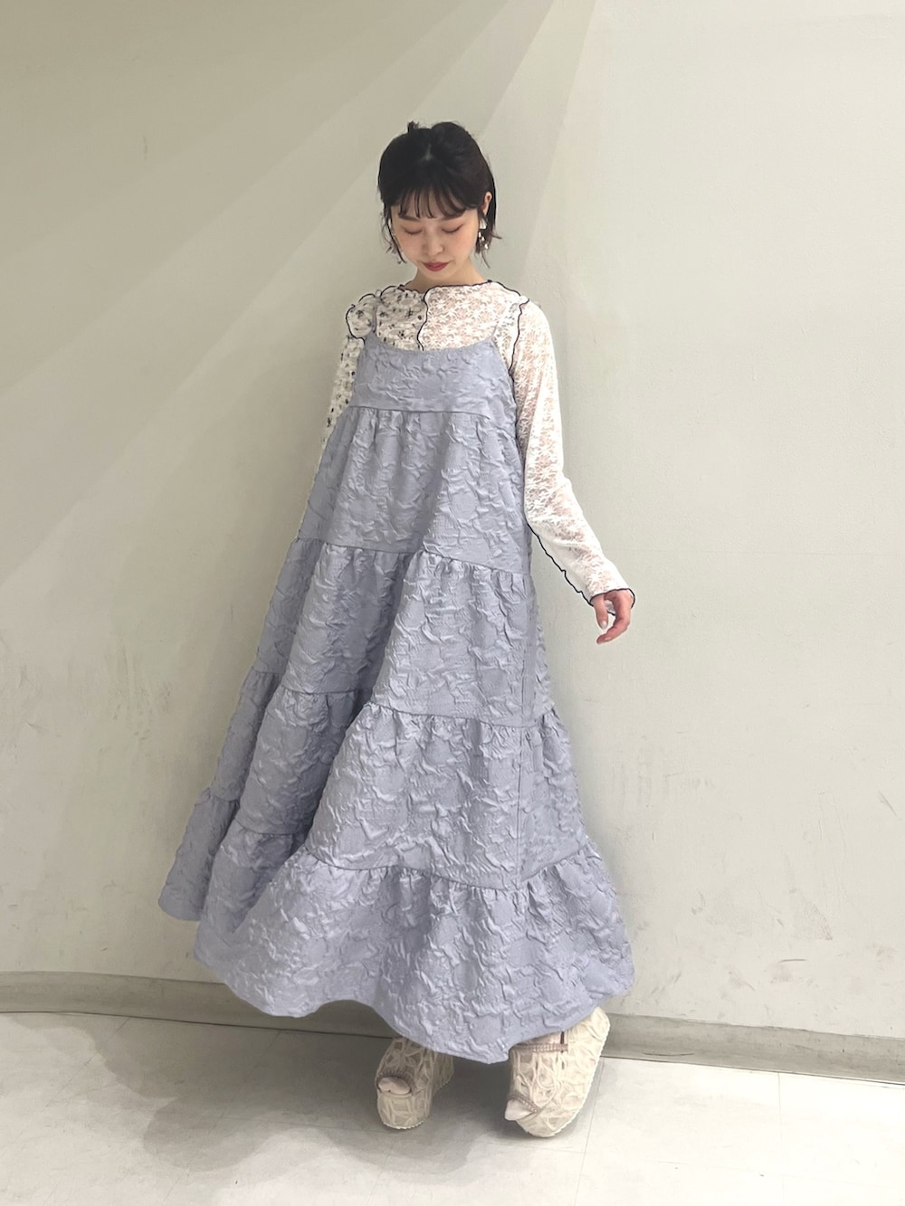 パープル系のワンピース、ホワイト系のTシャツ/カットソー、ホワイト系のサンダルを着用したレディースの夏コーディネートの3枚目の写真