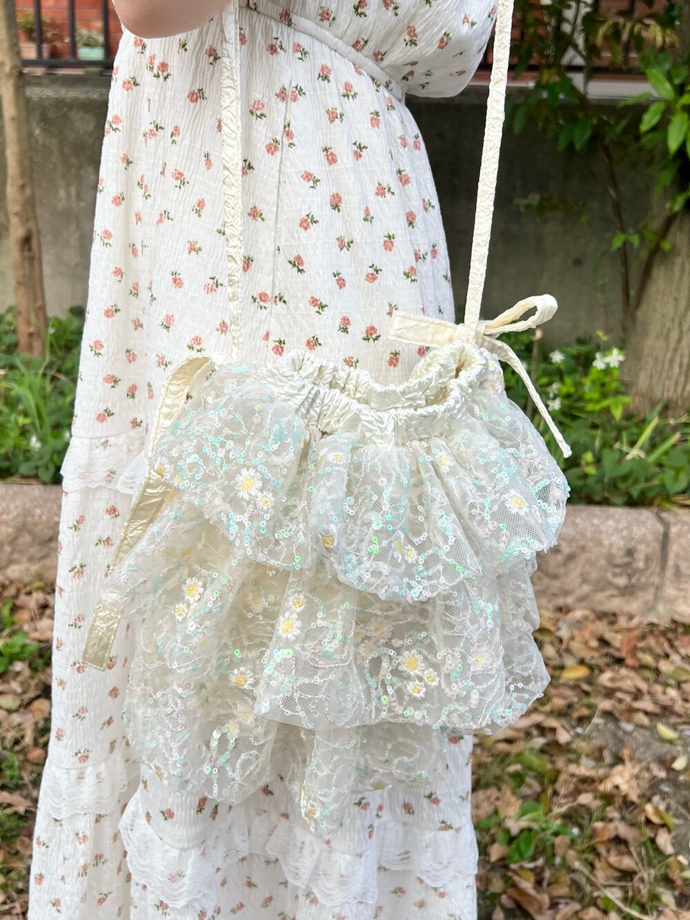 ホワイト系のワンピース、ホワイト系のショルダーバッグ、ベージュ系のサンダルを着用したレディースの春コーディネートの8枚目の写真