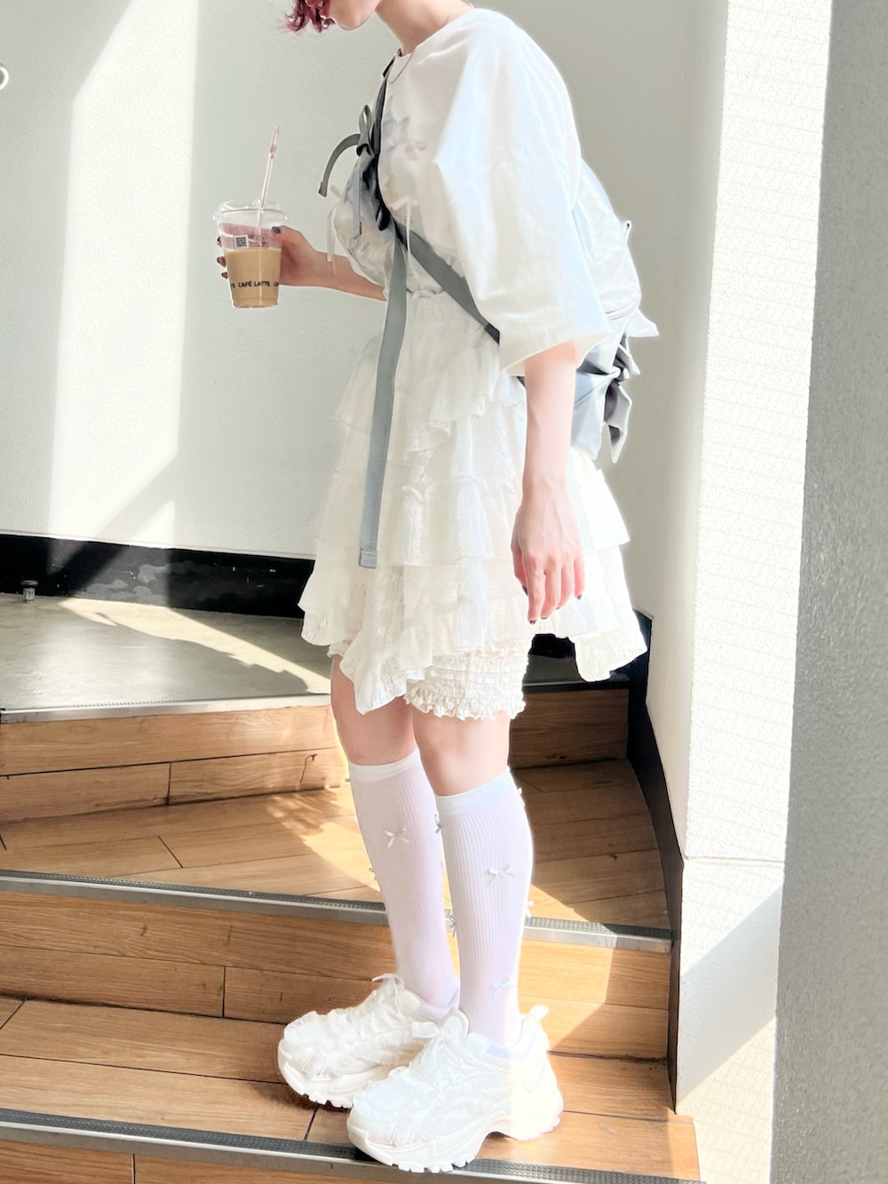 ホワイト系のTシャツ/カットソー、ホワイト系のスカート、ホワイト系のスニーカーを着用したレディースの春コーディネートの3枚目の写真