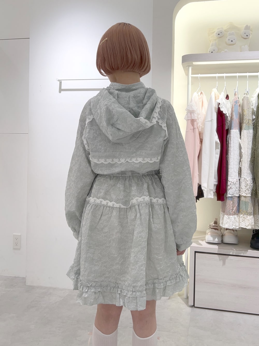 グリーン系のワンピース、ホワイト系のバックパック/リュック、ホワイト系のスニーカーを着用したレディースの秋コーディネートの9枚目の写真