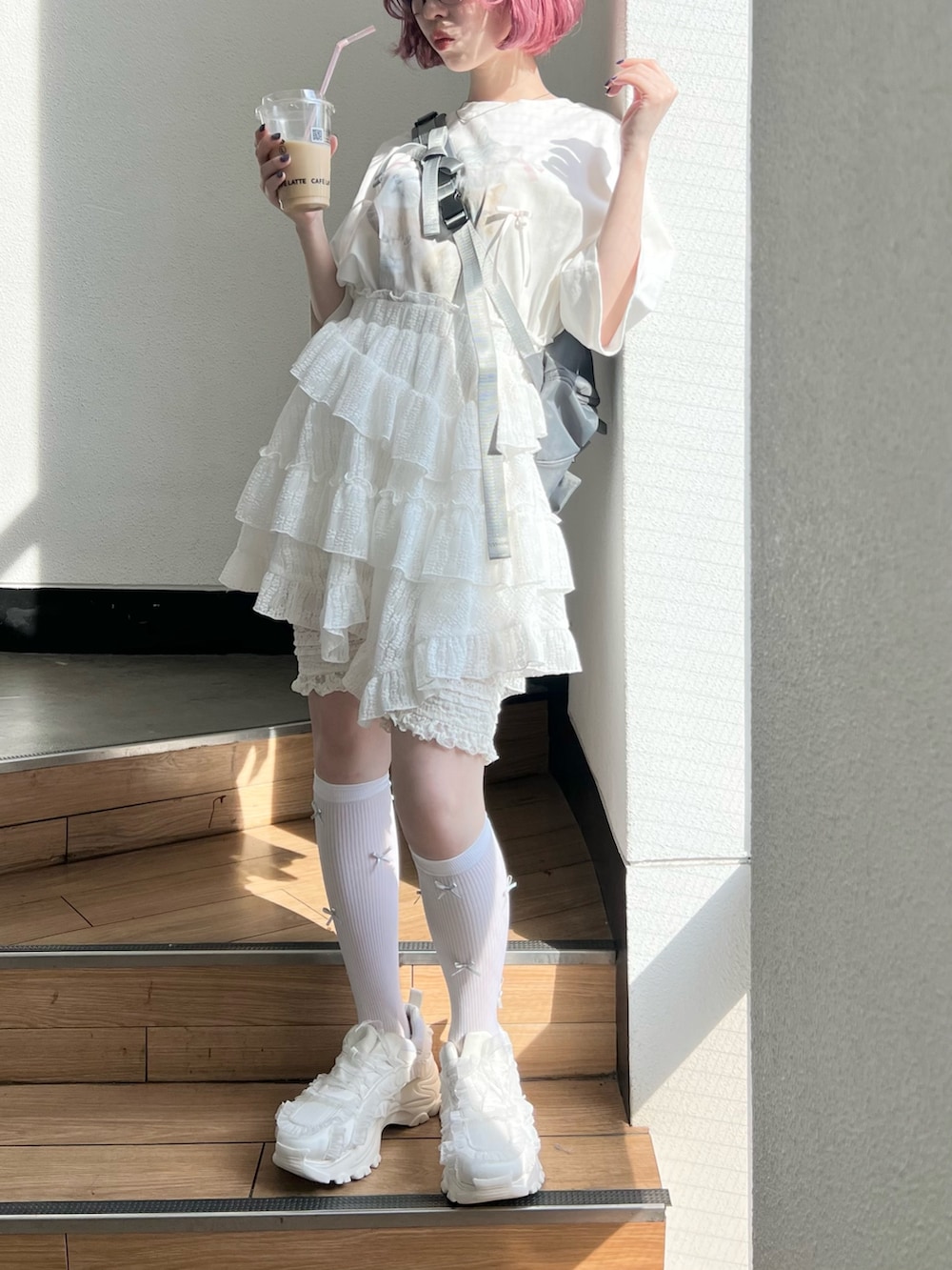 ホワイト系のTシャツ/カットソー、ホワイト系のスカート、ホワイト系のスニーカーを着用したレディースの春コーディネートの2枚目の写真