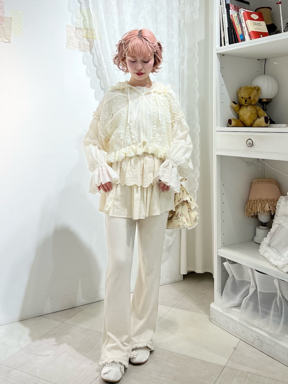 ホワイト系のスニーカー、ホワイト系のスウェットパンツ、ホワイト系のショルダーバッグを着用したレディースの冬コーディネートの2枚目の写真