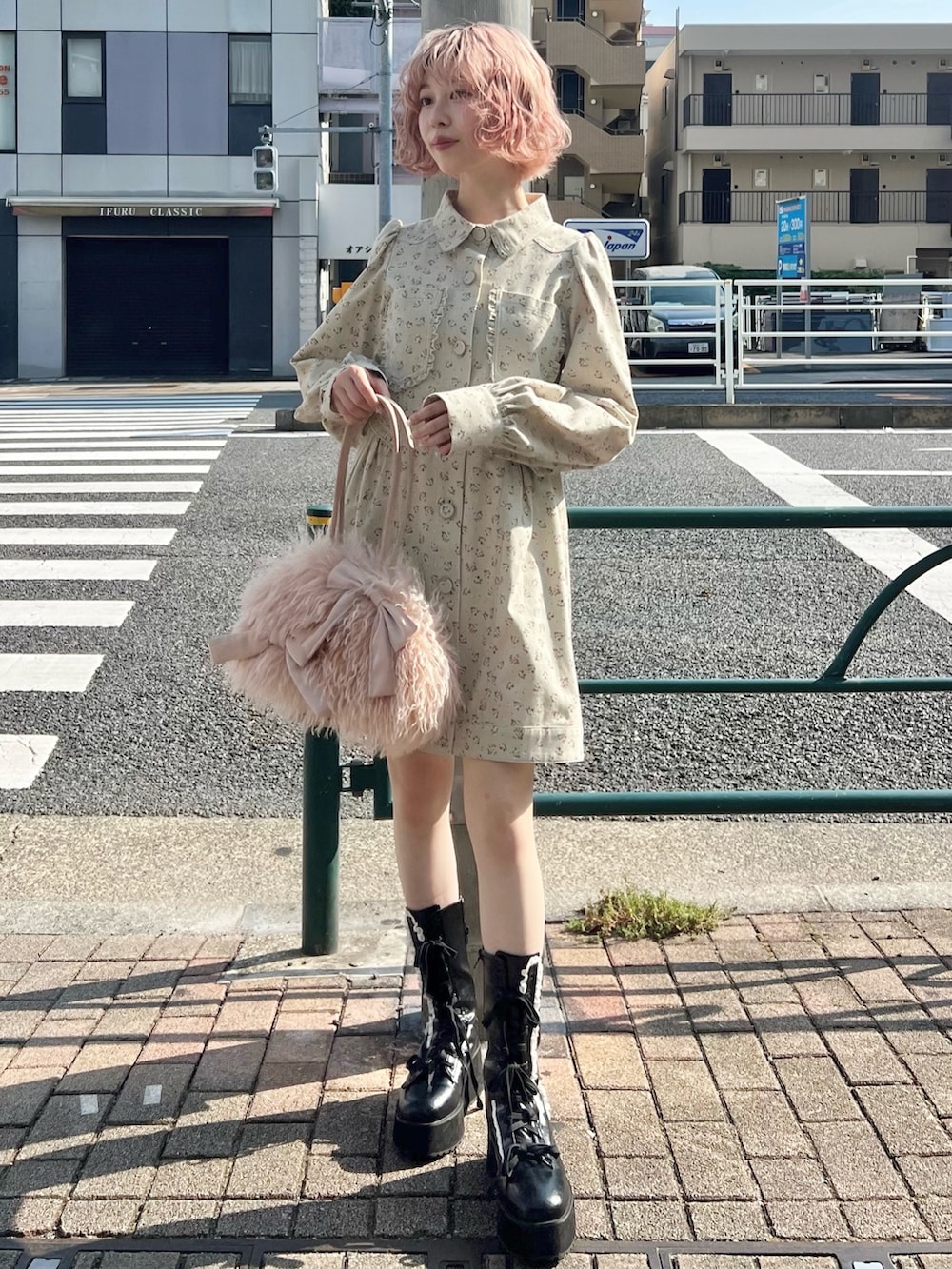 グリーン系のワンピース、ブラック系のブーツ、ピンク系のボストンバッグを着用したレディースの夏コーディネートの2枚目の写真