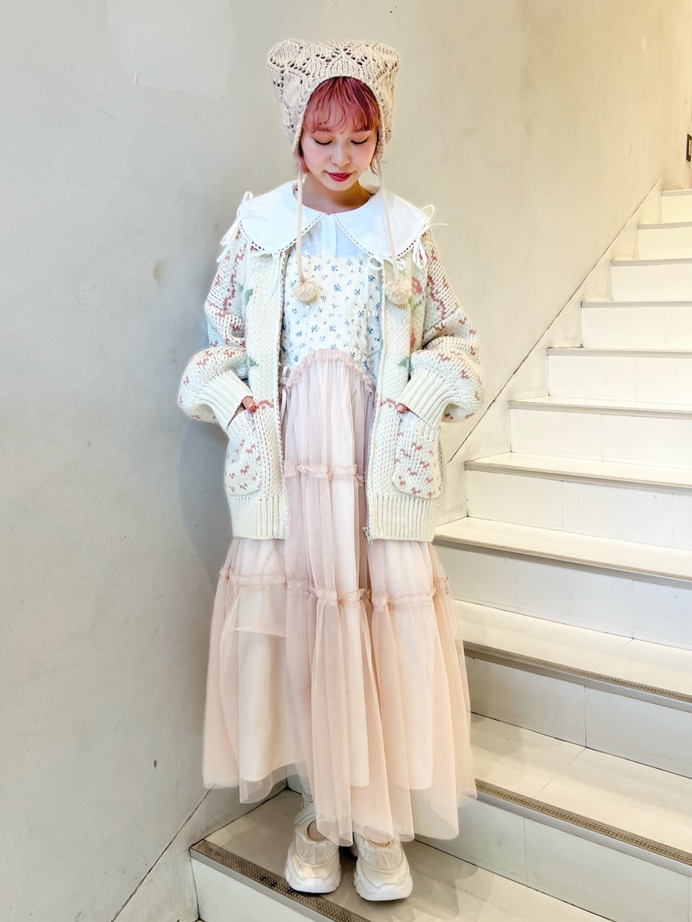 ピンク系のカーディガン/ボレロ、ホワイト系のシャツ/ブラウス、ピンク系のワンピースを着用したレディースの冬コーディネートの2枚目の写真