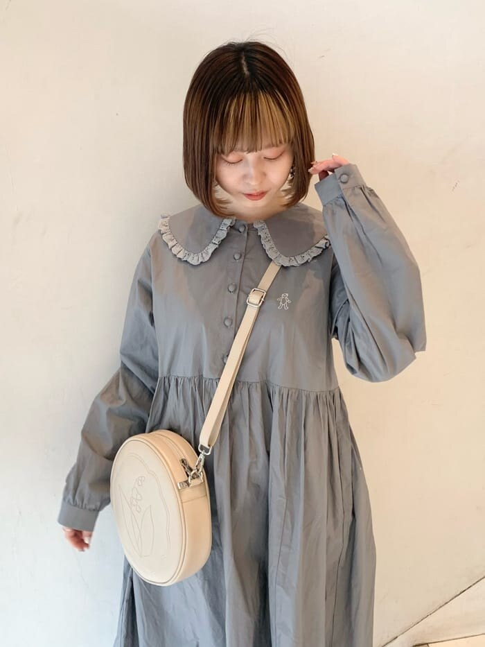 ベージュ系のカーディガン/ボレロ、ホワイト系のスニーカー、ホワイト系のショルダーバッグを着用したレディースの冬コーディネートの3枚目の写真