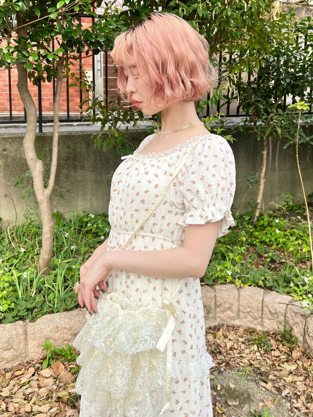 ホワイト系のワンピース、ホワイト系のショルダーバッグ、ベージュ系のサンダルを着用したレディースの春コーディネートの6枚目の写真