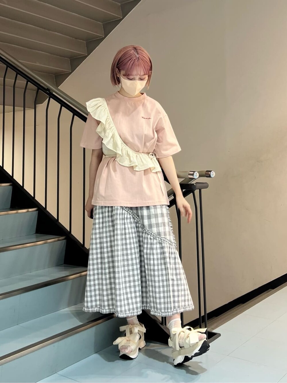 グレー系のスカート、ホワイト系のチューブトップ、ホワイト系のサンダルを着用したレディースの夏コーディネートの3枚目の写真