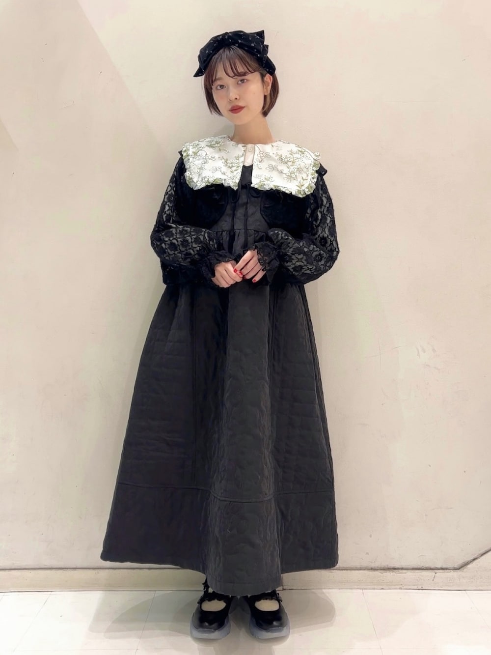 ブラック系のワンピース、ブラック系のカーディガン/ボレロ、ブラック系のスニーカーを着用したレディースの冬コーディネートの7枚目の写真